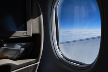 Porthole sky view. Commercial airplane window view from passenger seat