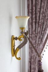 gilded vintage lamp on a white wall