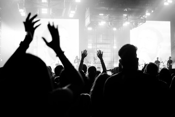 people at a concert with their hands in the air dancing and singing 