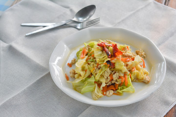 stir fried cabbage  with mince chicken breast, red dried chili, slice carrots on white dish for served with rice. Thai delicious food for dinner.
