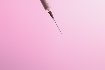 Close up of syringe isolated on pink with copy space