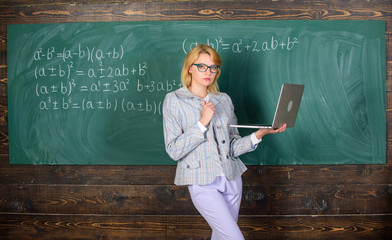Teacher blonde woman with modern laptop surfing internet chalkboard background. School innovation....