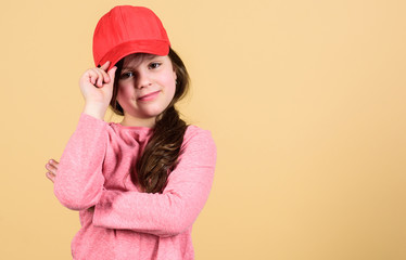 Cutie in cap. Stylish accessory. Kids fashion. Feeling confident with this cap. Girl cute child wear cap or snapback hat beige background. Little girl wearing bright baseball cap. Modern fashion