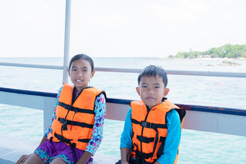 Fototapeta premium Portrait of Asian boy and girl on boat at the beach on summer