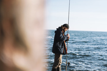 Handsome brutal bearded fisherman wearing coat