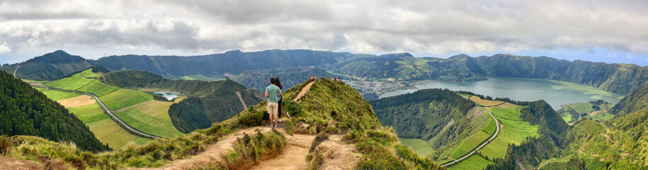 Young couple enjoy the panoramic view of Crater Sete Cidades from Pico da Cruz at Sao Miguel, Azores