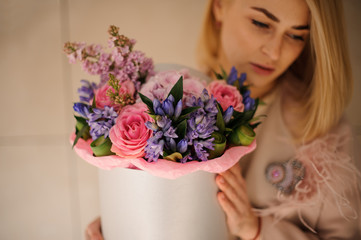 Attractive girl with bouquet in hat box