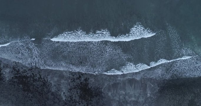 Aerial top down shot of waves breaking on Talisker bay in Isle of Skye, Scotland.