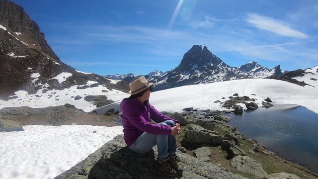 hiker woman resting and looking the Pic du Midi Ossau in the french Pyrenees mountains