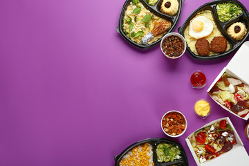 Containers with delicious food on color background