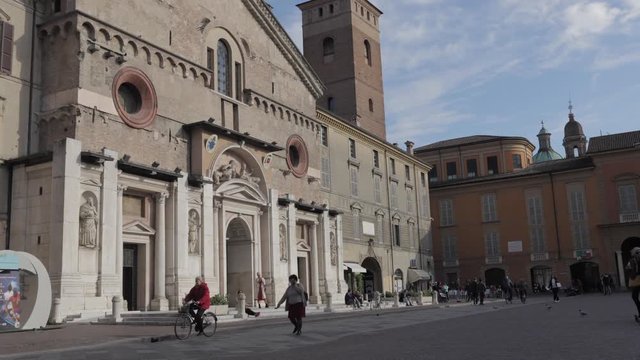 Reggio Emilia, Italy - May 16, 2019: Time lapse in front of the Cathedral of Reggio Emilia in Emilia Romagna, Italy, during a sunny day with people walking