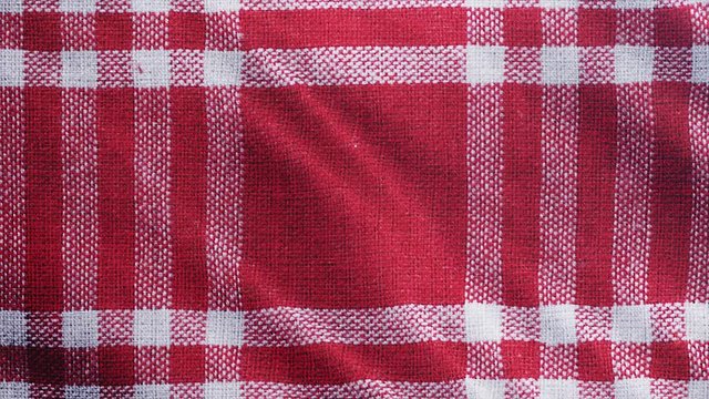 Red white tablecloth, piRed white tablecloth, picnic gingham is waving. Close up macro shot checkered fabric cloth background.cnic gingham is waving. Checkered fabric cloth background.