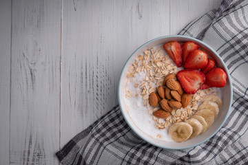Breakfast healthy muesli food. Ingredients. Bowl with oatmeal on white background. Top view