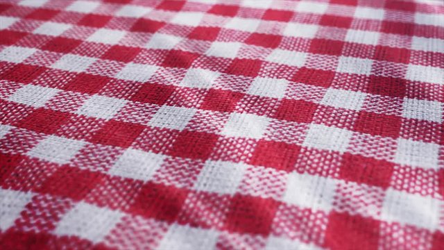 Red white tablecloth, piRed white tablecloth, picnic gingham is waving. Close up macro shot checkered fabric cloth background.cnic gingham is waving. Checkered fabric cloth background.