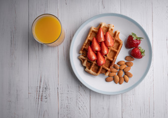 Breakfast - waffles with fresh berries and nuts. Orange juice. Fresh healthy lunch.