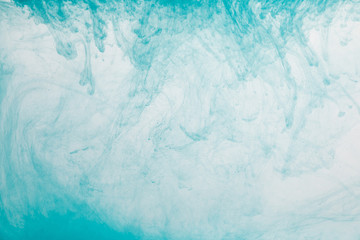 Fototapeta premium Close up view of light blue paint swirls in water
