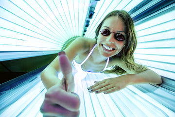 Cheerful woman inside of a sunbed