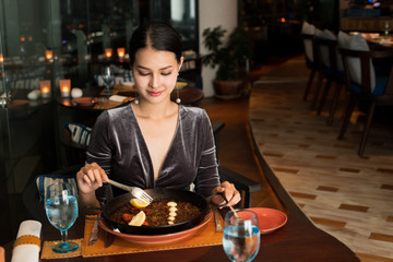 Asian Beautiful Woman have Dinner in luxury roof top restaurant with secret recipe Menu on plate course set of Spanish food Cuisine culinary which a bit hot and unique taste on wooden table.