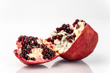 on a white background, isolated, blood-red, splintered pomegranate fruit