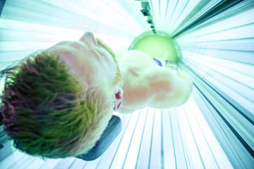 Muscular man inside a sunbed