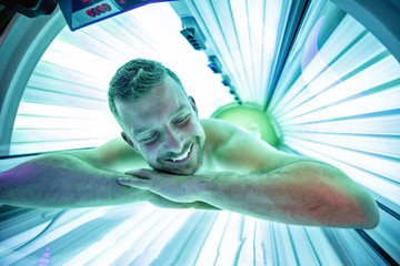 Man in sunbed relaxing and enjoying