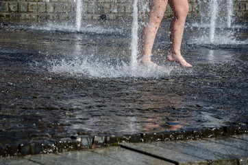 children play with splashes in the street fountain