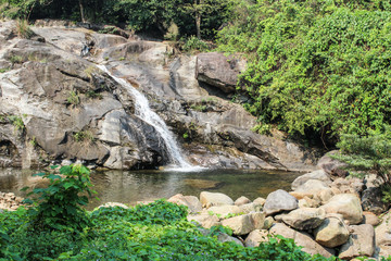 Small stream rocky waterfall in tropical jungle in Lang Co, Hue, Vietnam