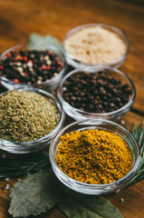 variety of spices in round glass bowls - ground ginger, hops-suneli, kari, black pepper and a mixture.
