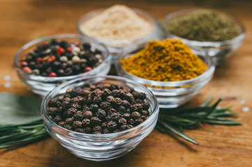 Round glass bowl with spice - black pepper in a pea.