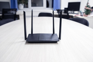 on a light semicircular table is a black router for Internet access