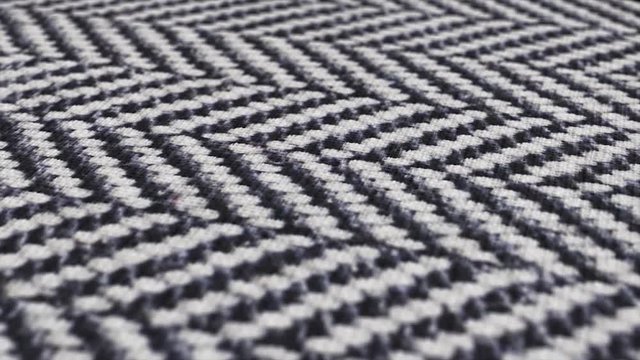 Herringbone fabric cloth close up background. Black and white tweed pattern, weaving, textile material.
