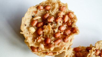Peanut Peyek on white background. Peanut Rempeyek or Peyek is a deep-fried savoury Javanese cracker made from  rice flour with peanut by crispy flour batter. Indonesian food.
