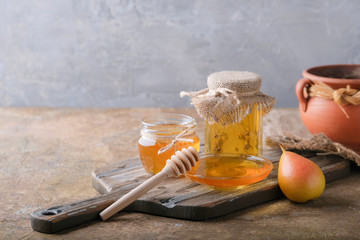 Jars of honey and pears on the table.