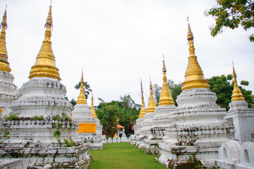 Fototapeta premium Many golden pagodas on the courtyard of temple in northern thailand, with blue sky background.