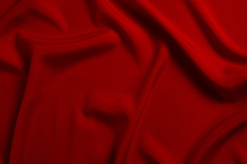 Red silk or satin luxury fabric texture can use as abstract background. Top view.