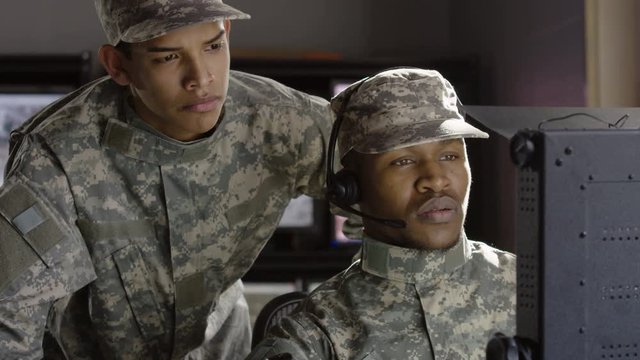 2 Military drone operators looking at computer screen