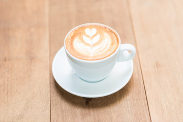 Latte art texture coffee in white cup on wood table