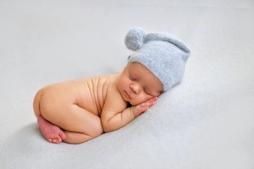 Sleeping newborn boy in the first days of life on white background