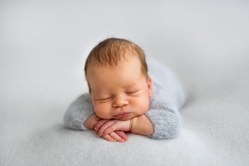 Sleeping newborn boy in the first days of life on white background
