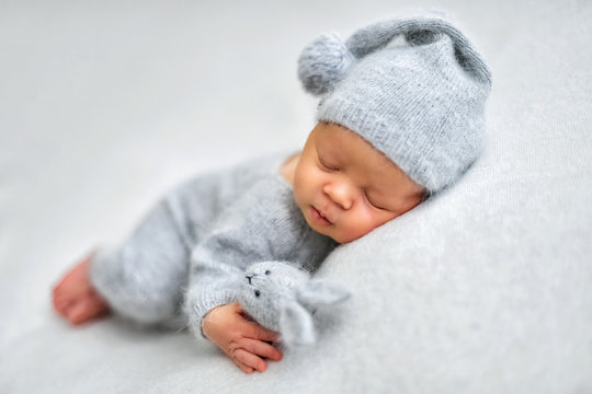Sleeping newborn boy in the first days of life on white background