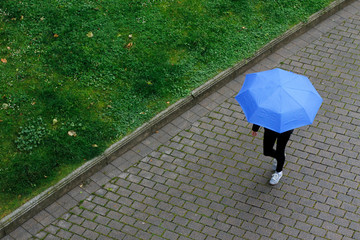 Walking under the rain with umbrella