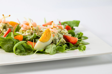 Spring salad with shrimps, egg and strawberry.