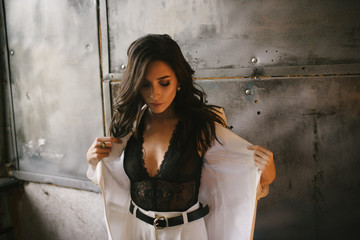 Young sexy brunette woman in jacket and pants posing in the studio