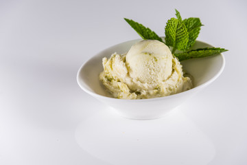 Genuine Italian frozen ice cream with green ice cream pistachio or mint..Delicious frozen icecream..White surface bright background