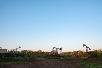 Obraz premium Oil and gas production equipment running at sunset