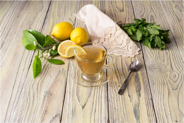 Mint tea and lemons on a wooden table close-up