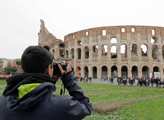 young boy takes photos of Colosseum