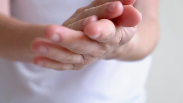 Hands of a young woman applying hand cream, hands massage