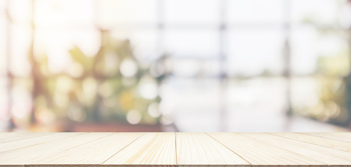 Empty wooden table top with cafe restaurant coffee shop window interior abstract blur defocused...