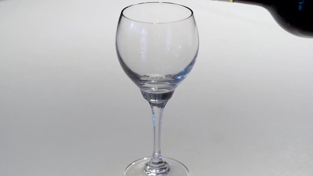 Das eingie&szlig;en eines Rotwein in ein Weinglas in Full HD Zeitlupe